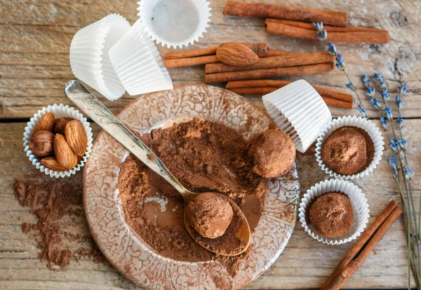 Making chocolate truffles. Homemade round chocolate candies with cocoa powder, almonds and cinnamon