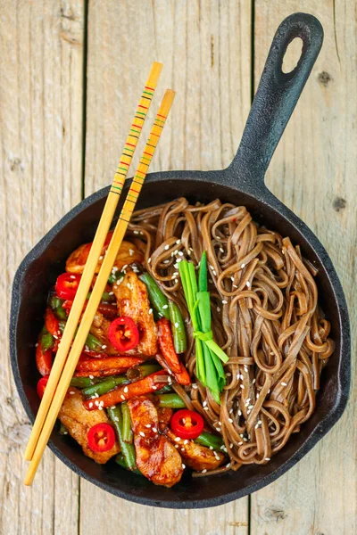 Buckwheat soba noodles with chicken, green beans, carrots, onions, chilli and sesame seed
