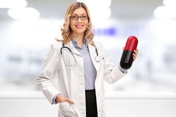 Female doctor holding a huge pill