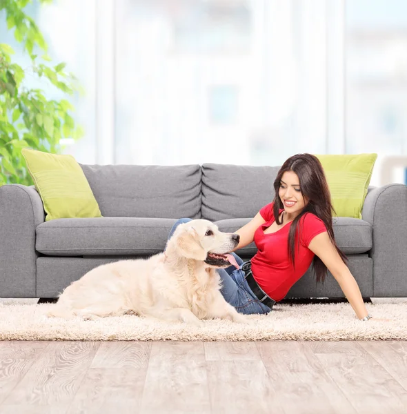 Young woman petting dog at home
