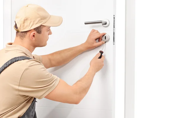 Locksmith installing a lock on a door