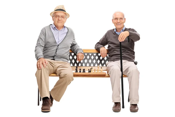 Two old men with a chessboard on bench