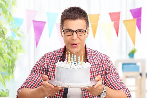 Joyful man blowing candles on a cake