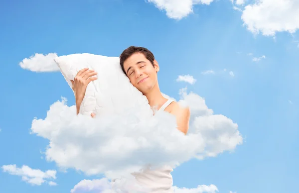 Joyful man sleeping up in clouds