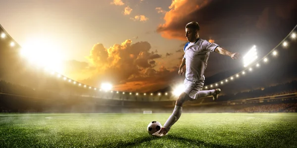 Soccer player in action on sunset stadium panorama background