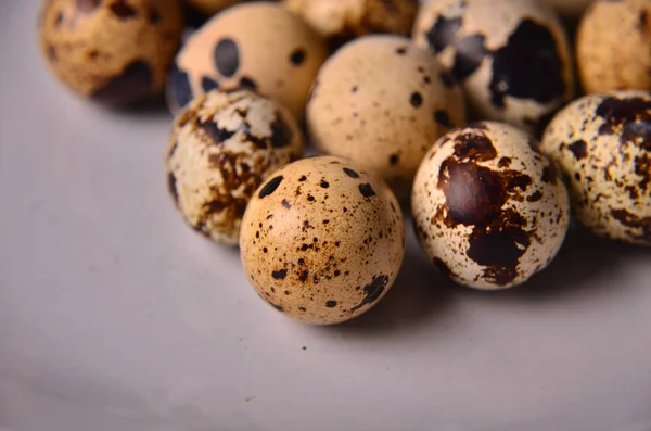 Plate with quail eggs, salt, olive oil and mushrooms on wooden table. Top view