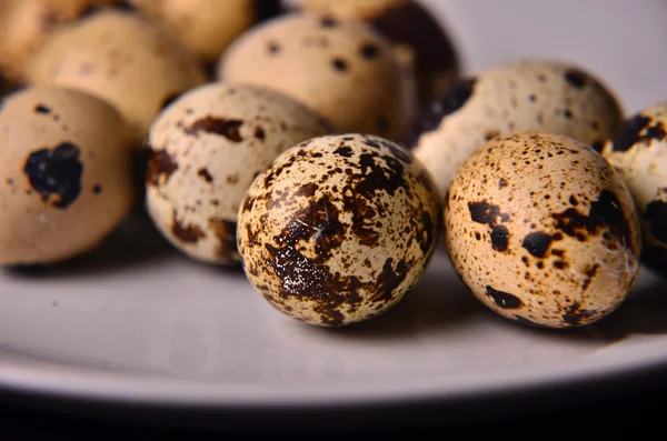 Plate with quail eggs, salt, olive oil and mushrooms on wooden table. Top view