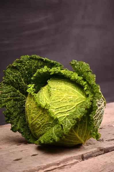 Close up of organic savoy cabbage on the wooden background