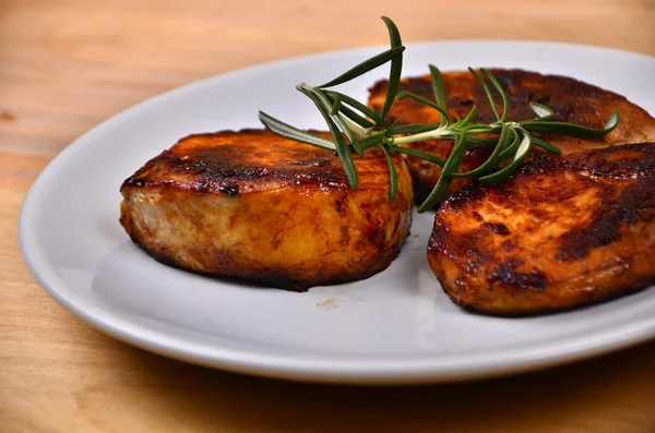 Juicy flank steak in an circle white plate decorated with rosemary