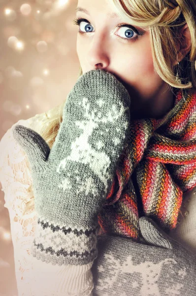 Beautiful blonde surprised woman wearing warm reindeer mittens.