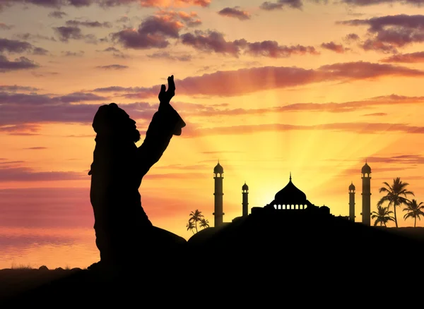 Muslim praying on a background of a mosque