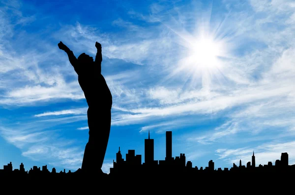 Silhouette of a businessman with his hands up