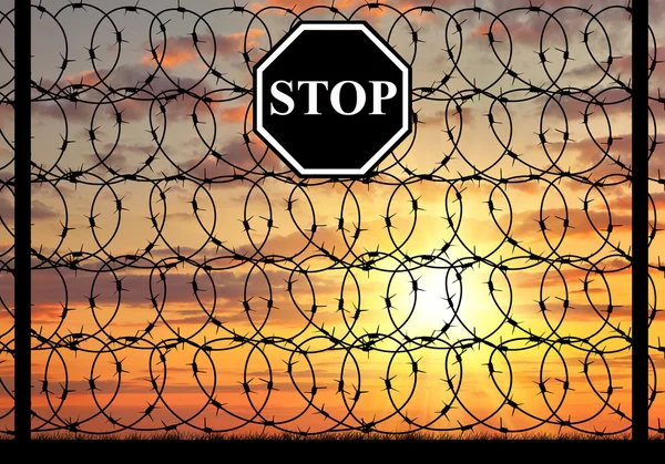Silhouette  a fence on border with stop sign