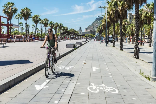 Girl cycling on the promenade in Barcelona