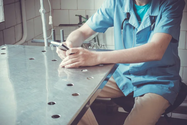 Medical doctor sitting at desk with phone