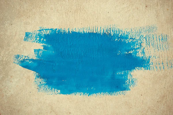 Abstract simple background brushstrokes of blue paint on a beige background