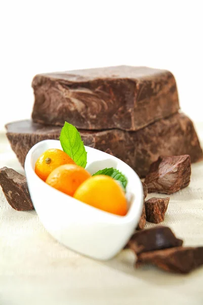 Brown chocolate chunk block and fresh kumquat. This is perfect harmony of tasting flavor chocolate and orange, lemon, exotic for cake, muffin, ice cream, fondue, pie and your favorite desserts.