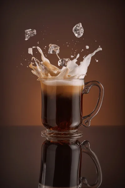 Splash of ice coffee isolated on brown background