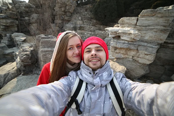 Beautiful couple making love selfie on a background of mountains in the park