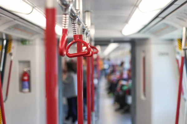 Inside the subway car. Red handrails in the subway.