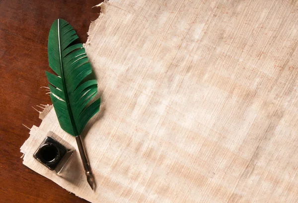 Quill pen and papyrus paper