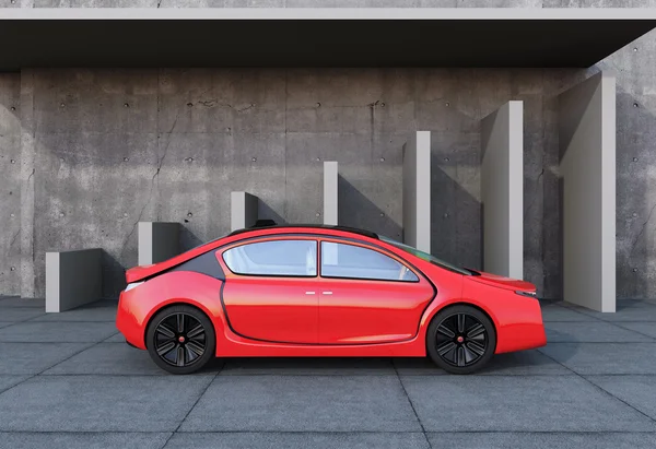 Red electric car in front of  concrete architecture