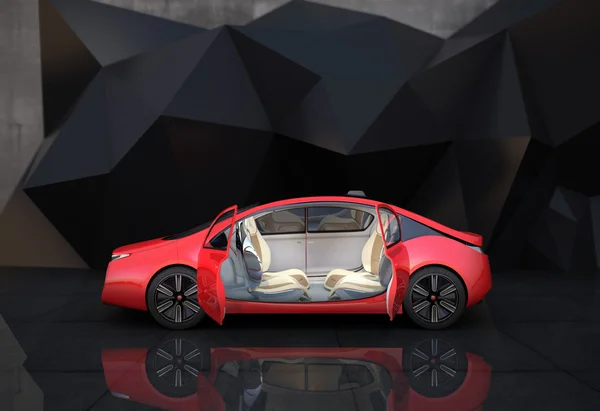 Side view of red autonomous car in front of geometric object background