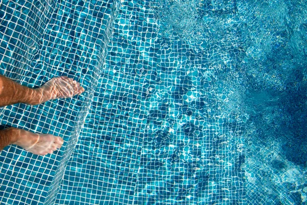 Man feet in swimming pool
