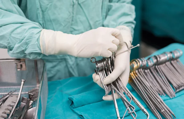 Scrub nurse prepare medical instruments for open heart surgery