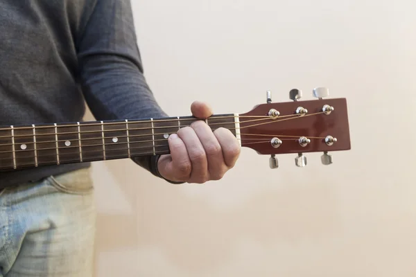 The guy playing the guitar. The hand on the strings. Guitar close-up