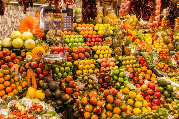 Market stall with fruits and vegetables in the market hall La Boqueria in Barcelona, spain