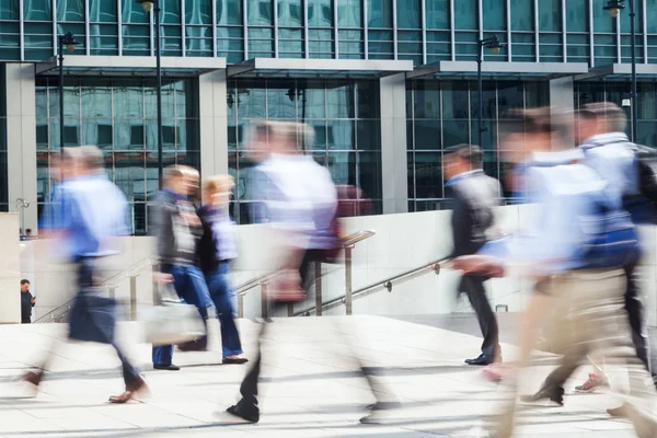 Walking business people in motion blur