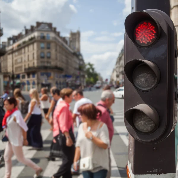 Traffic lights in the foreground with a street scene in the blurred background in London, UK