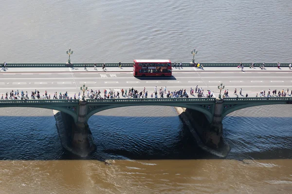 Aerial view of the Westminster Bridge with crowds of people and a typical double decker bus in Westminster, London, UK