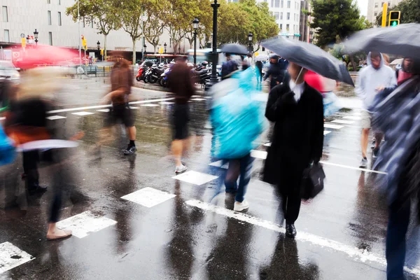 People in motion blur on the move in the rainy Paris, France