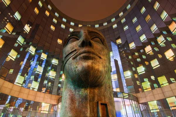 Night view of a sculpture of Igor Mitoraj in front of an office building in La Defense, Paris, France