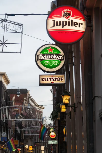 Neon signs of beer brands in an alley of the old town of Amsterdam, Netherlands, at dawn