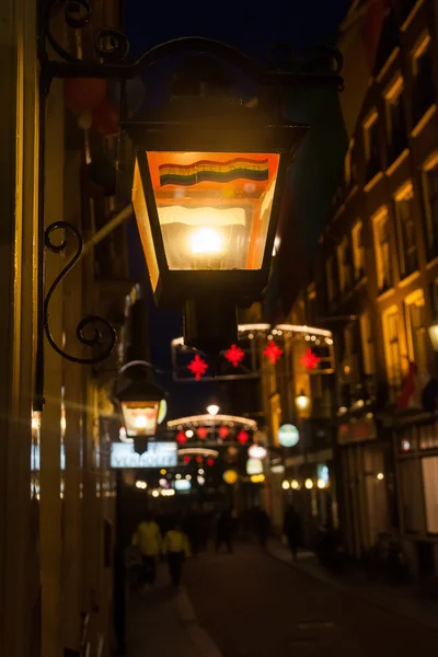 Dark alley with street lighting in the old town of Amsterdam, Netherlands, at night