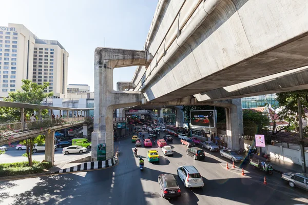 Street scene under the skytrain in Silom district with unidentified people in Bangkok, Thailand