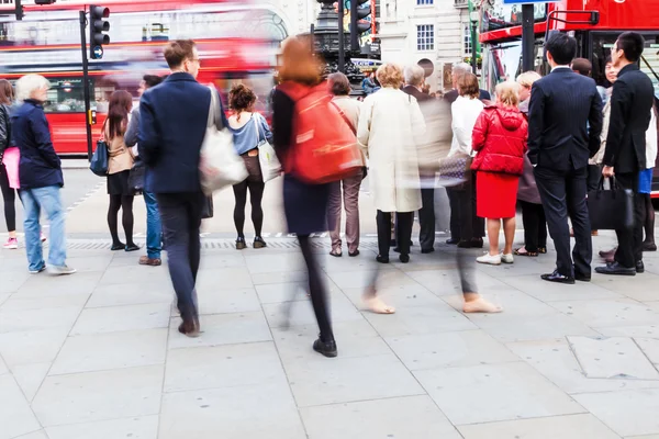 Crowd of people in motion blur crossing a street in London, UK