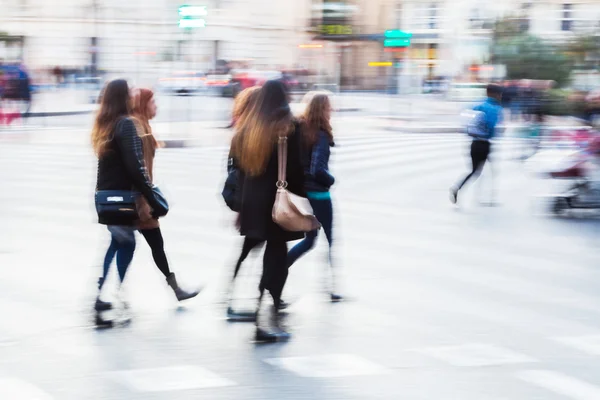 People in motion blur crossing the street