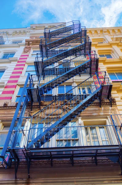 Old residential buildings with fire escape stairs in Soho, New York City