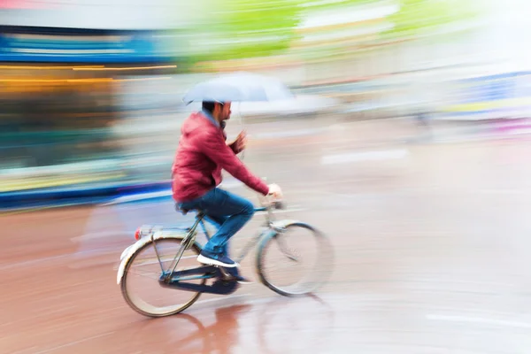 Bicycle rider in the rainy city