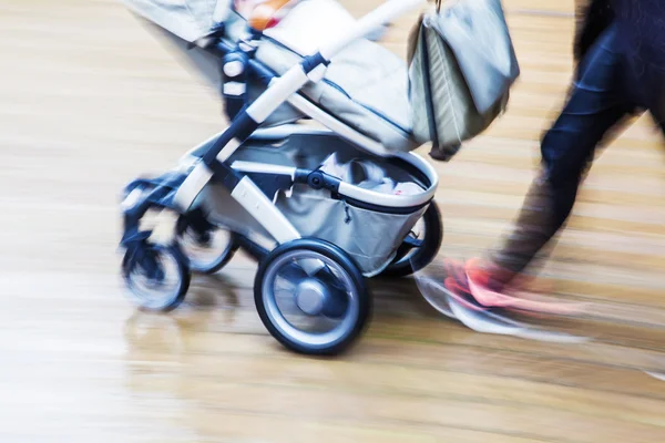 With baby buggy in the city in motion blur