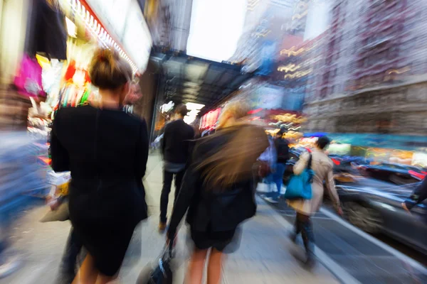 Creative zoom picture of walking women in NYC at dawn