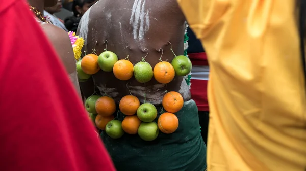 Thaipusam rituals, carry milk pots hooked on the back