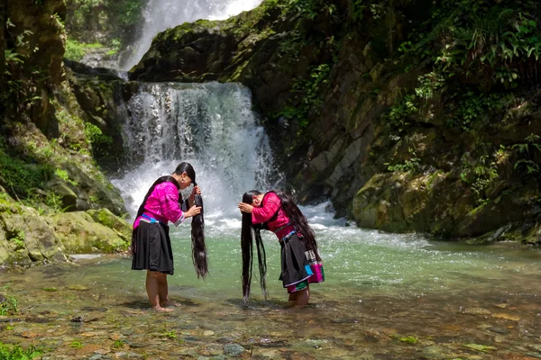 Unidentified women wash their hair at a stream