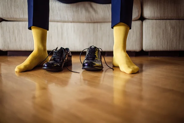 The man wears shoes. Yellow socks.