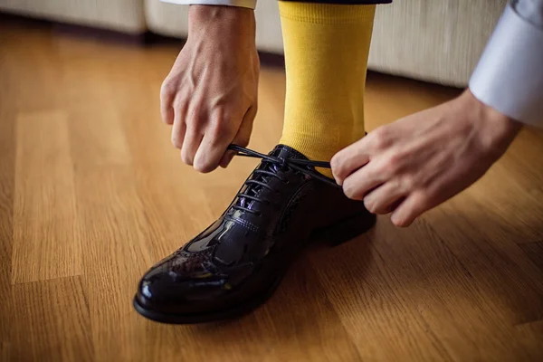 The man wears shoes. Yellow socks.