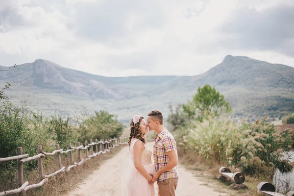 Pregnant woman with her husband on the mountains background